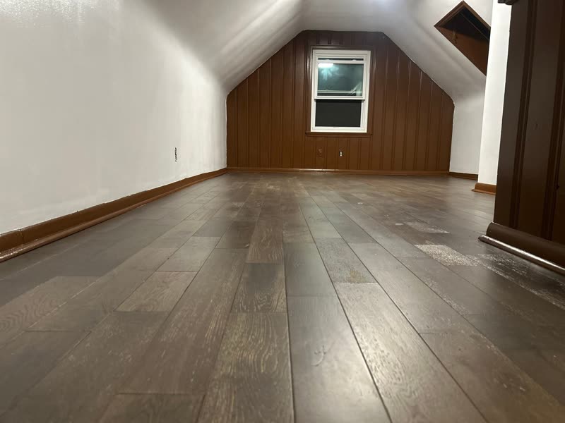 Attic bonus room after — new wood-look flooring and clean, refreshed walls